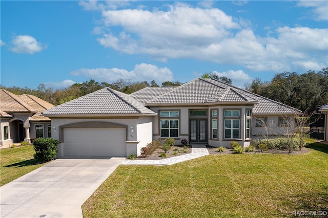 mediterranean / spanish-style home with a garage, a front yard, and french doors