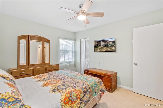 bedroom featuring ceiling fan, a closet, and light carpet