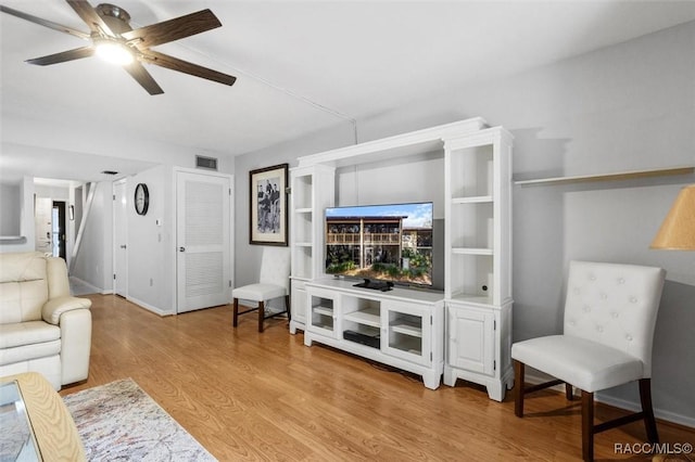 living room featuring light hardwood / wood-style flooring and ceiling fan