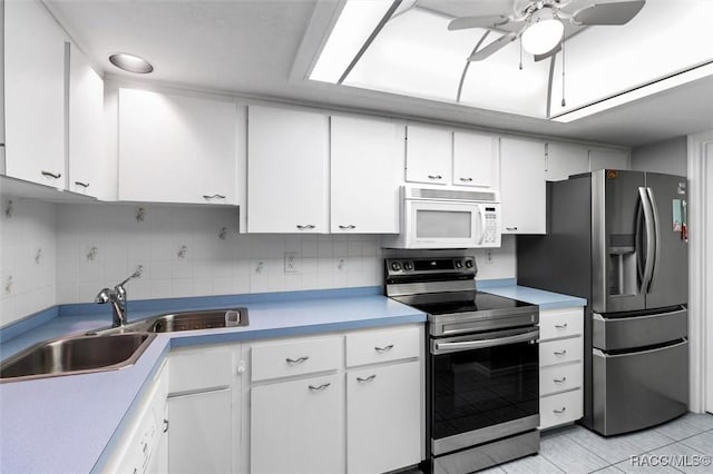 kitchen with sink, backsplash, white cabinets, and appliances with stainless steel finishes