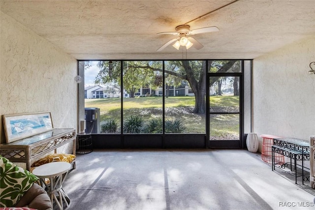 unfurnished sunroom featuring ceiling fan and a wealth of natural light