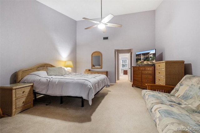 carpeted bedroom featuring ceiling fan and a towering ceiling