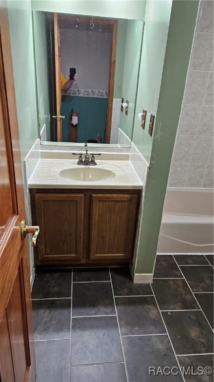 bathroom with vanity, tile patterned floors, and  shower combination