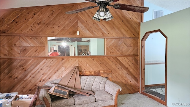 unfurnished room with light colored carpet, high vaulted ceiling, and wood walls