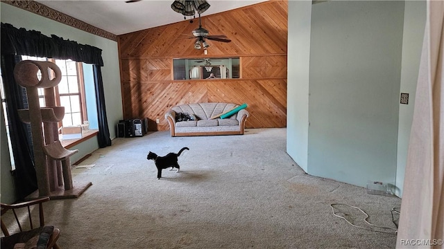 sitting room featuring ceiling fan, carpet flooring, and wooden walls