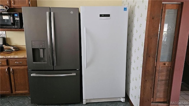 kitchen with white refrigerator, dark tile patterned flooring, and stainless steel fridge with ice dispenser