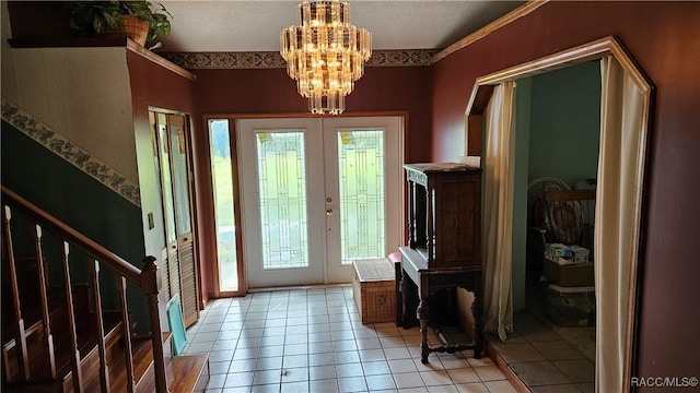 tiled entrance foyer featuring a notable chandelier and french doors