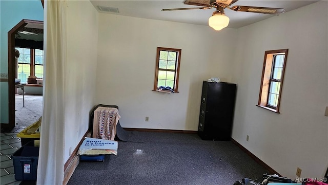 sitting room with plenty of natural light and ceiling fan