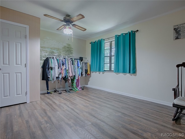 interior space with ceiling fan, wood-type flooring, and ornamental molding