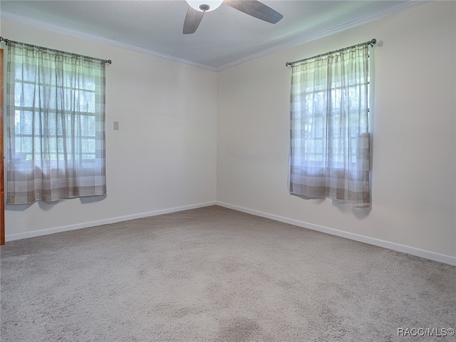 carpeted empty room featuring ceiling fan and crown molding