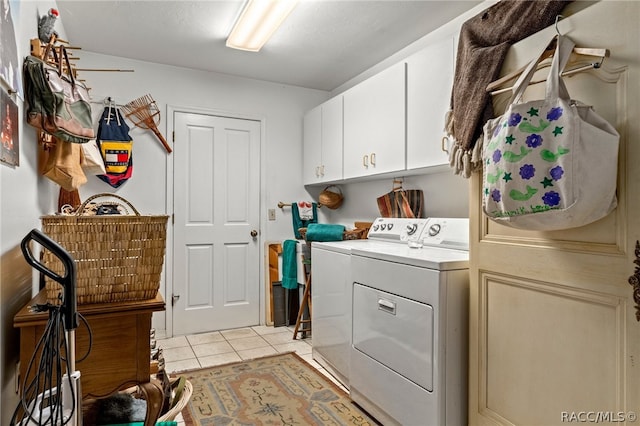 clothes washing area with separate washer and dryer, light tile patterned flooring, and cabinets