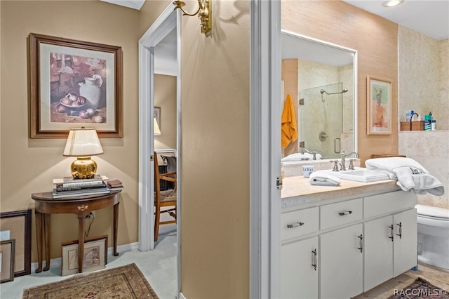 bathroom featuring a shower with door, vanity, and toilet