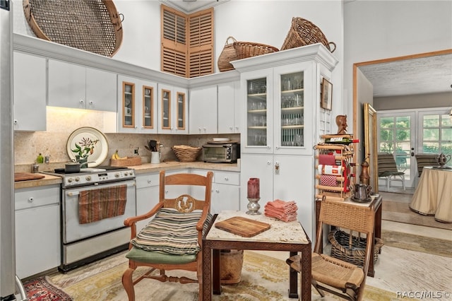 kitchen with white cabinets, range, and decorative backsplash