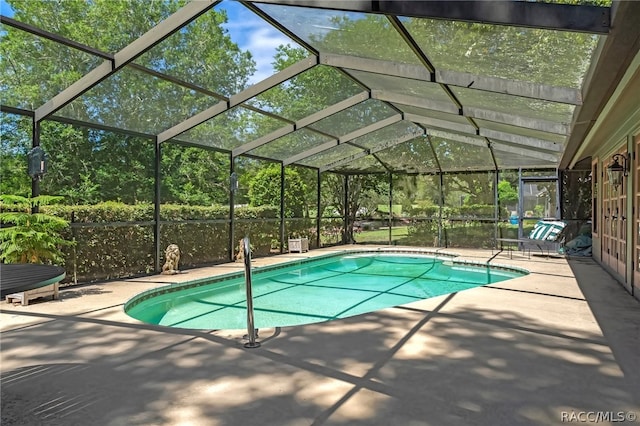 view of pool featuring glass enclosure and a patio