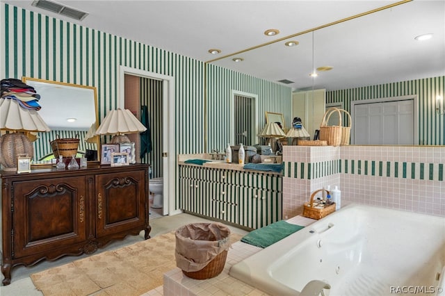 bathroom featuring a tub, vanity, and toilet