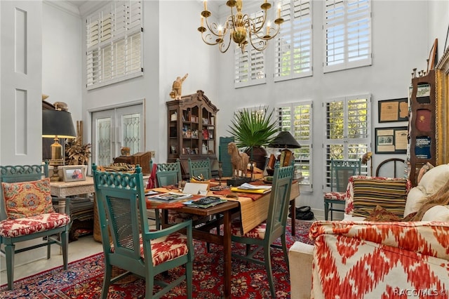 dining area featuring a towering ceiling and a chandelier