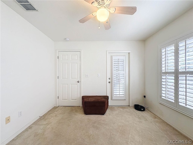 unfurnished room with light colored carpet and ceiling fan