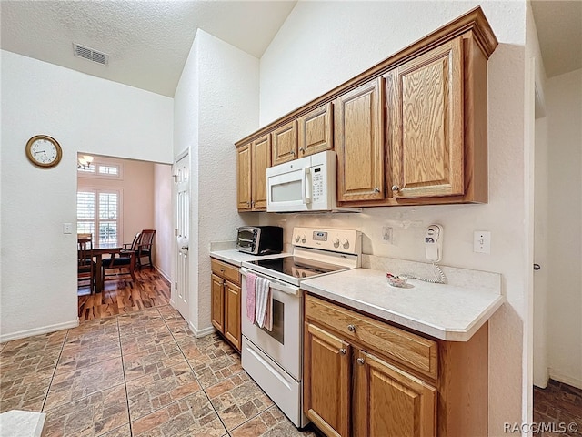 kitchen with a textured ceiling and white appliances