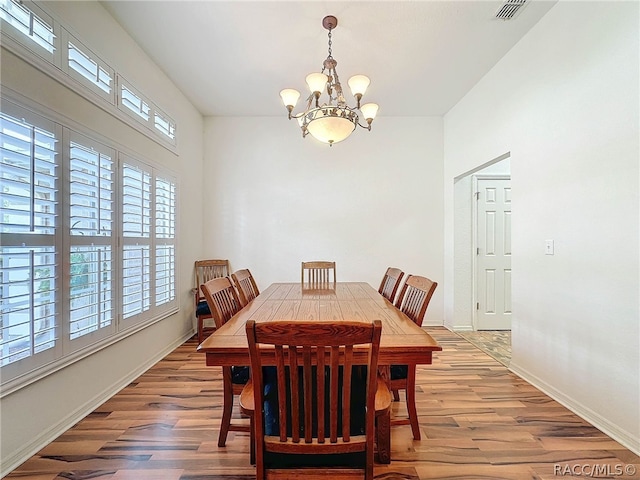 dining space featuring an inviting chandelier and hardwood / wood-style flooring