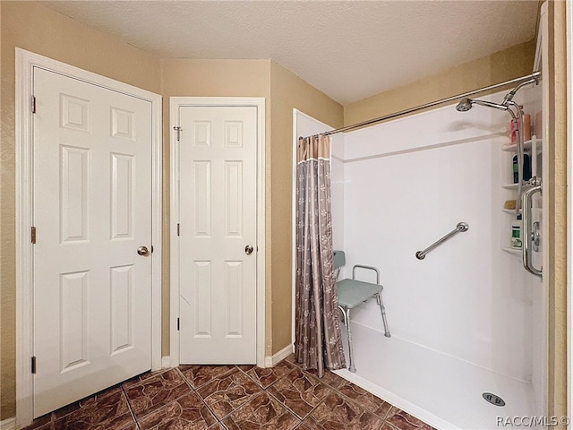 bathroom featuring a shower with shower curtain and a textured ceiling