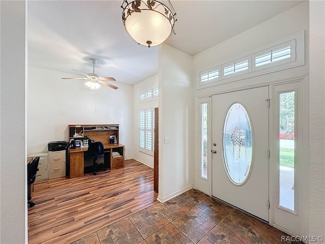 foyer entrance featuring a wealth of natural light, dark wood-type flooring, and ceiling fan