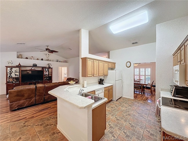 kitchen featuring dark hardwood / wood-style flooring, kitchen peninsula, vaulted ceiling, white appliances, and a kitchen bar