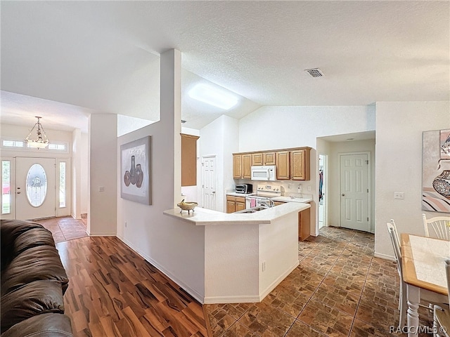 kitchen with dark hardwood / wood-style floors, kitchen peninsula, lofted ceiling, stainless steel electric stove, and a breakfast bar