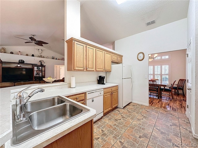 kitchen featuring ceiling fan, sink, kitchen peninsula, vaulted ceiling, and white appliances