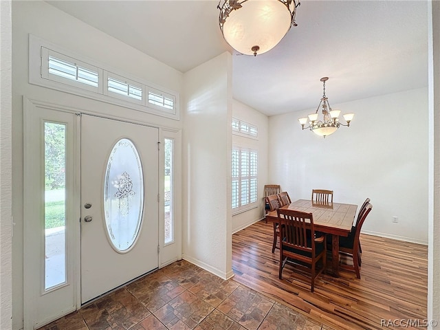 entryway with dark hardwood / wood-style floors and an inviting chandelier