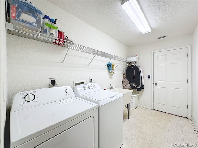 laundry room featuring sink, independent washer and dryer, and a textured ceiling