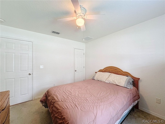 bedroom featuring a textured ceiling, carpet floors, and ceiling fan