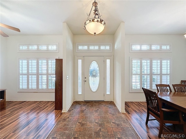 entryway featuring ceiling fan, a healthy amount of sunlight, and dark hardwood / wood-style flooring