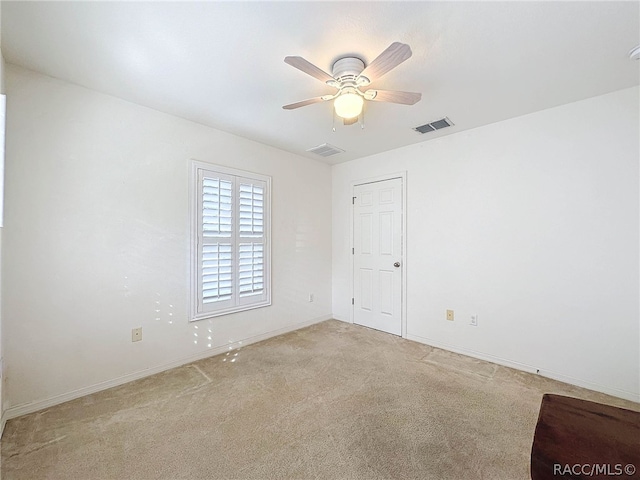 carpeted spare room with ceiling fan