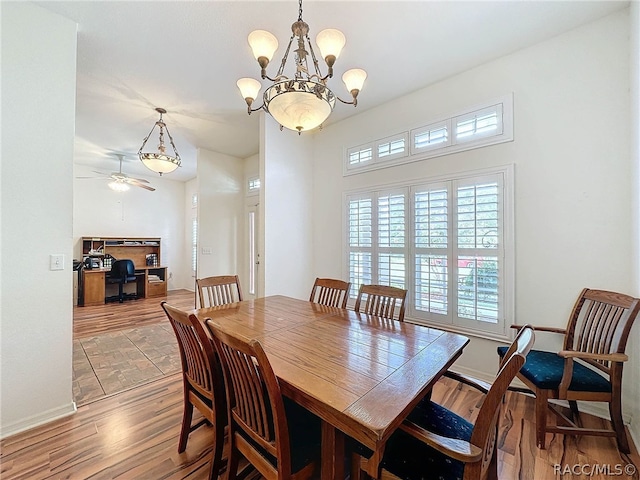 dining room featuring hardwood / wood-style floors and ceiling fan with notable chandelier