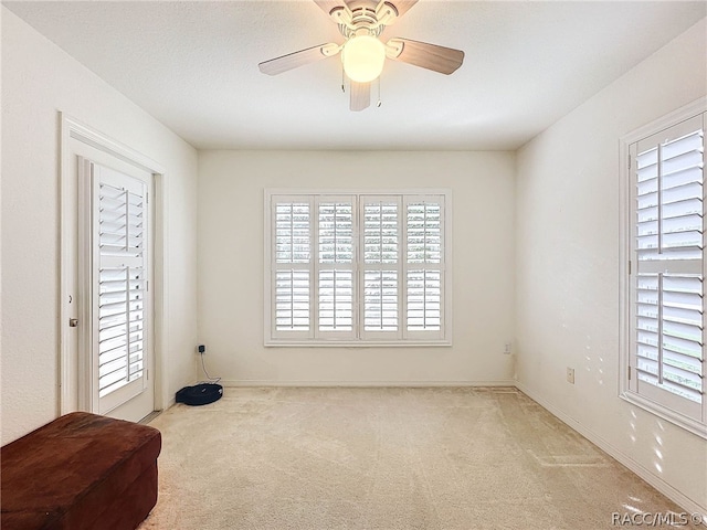 spare room with light colored carpet and ceiling fan