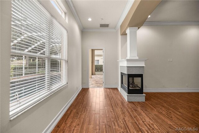 1789 N Sky Glen Path, Hernando, FL 34442 - unfurnished living room with a multi sided fireplace, ornamental molding, visible vents, wood finished floors, and baseboards