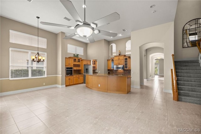 1789 N Sky Glen Path, Hernando, FL 34442 - kitchen featuring ceiling fan with notable chandelier, light tile patterned floors, arched walkways, a towering ceiling, and appliances with stainless steel finishes