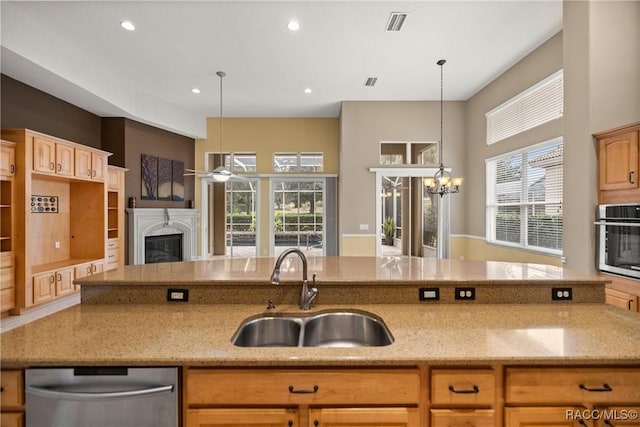 1789 N Sky Glen Path, Hernando, FL 34442 - kitchen featuring a sink, a wealth of natural light, light stone countertops, a glass covered fireplace, and stainless steel appliances