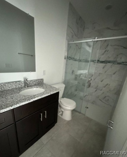 bathroom with vanity, a shower with shower door, and toilet