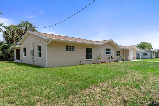 4306 E Gloria Dr, Hernando, FL 34442 - back of house with stucco siding, a yard, and a garage