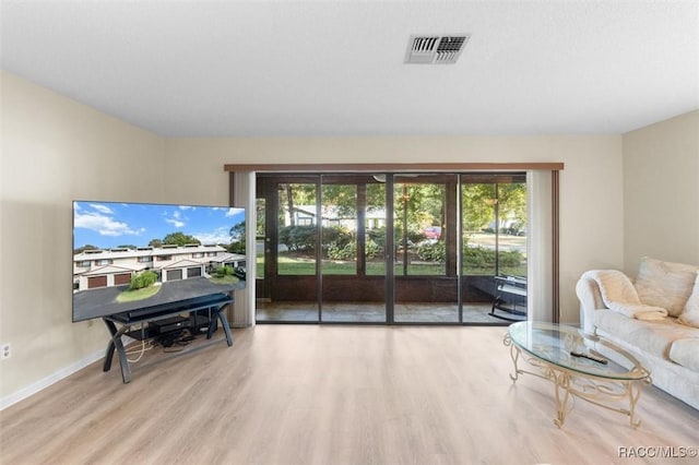 living room with light hardwood / wood-style floors and a healthy amount of sunlight