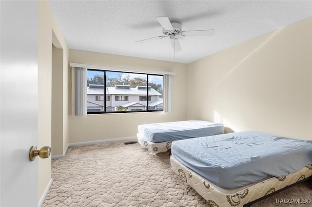 carpeted bedroom with a textured ceiling and ceiling fan