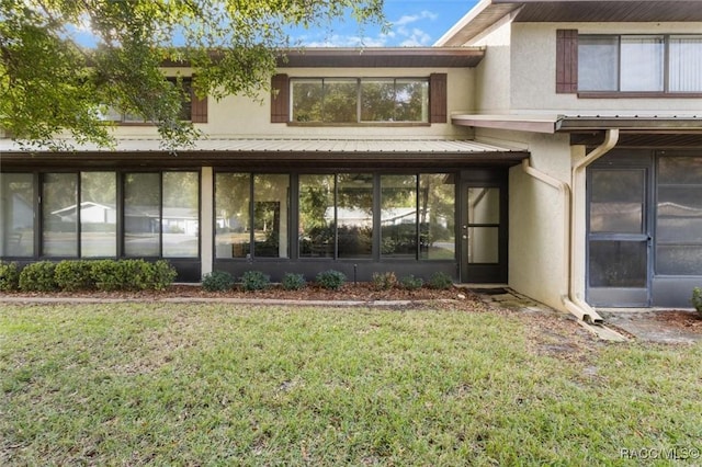 property entrance featuring a lawn