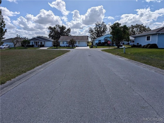 10482 S Clint Loop, Floral City, FL 34436 - view of asphalt road with a residential view, traffic signs, and curbs