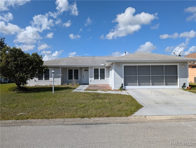 ranch-style house featuring a garage and a front lawn