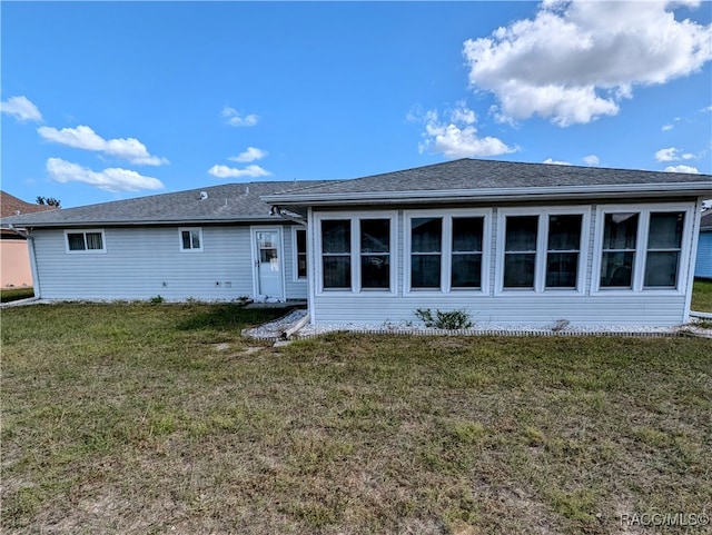 rear view of property with a yard