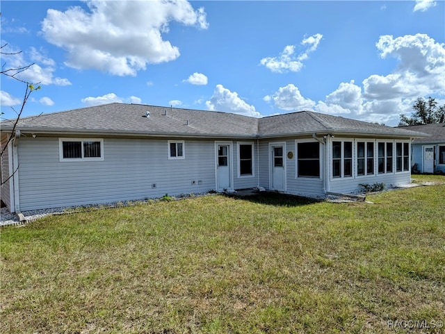 back of house with a sunroom and a yard