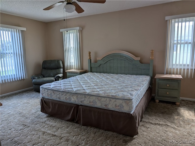 bedroom with a textured ceiling, carpet floors, and ceiling fan