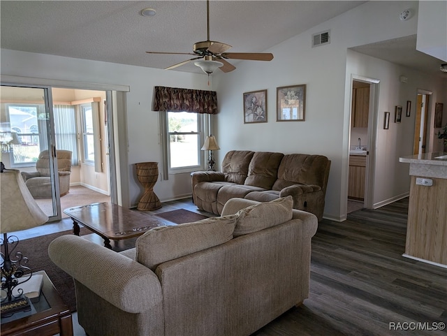 living room with lofted ceiling, sink, dark hardwood / wood-style floors, ceiling fan, and a textured ceiling