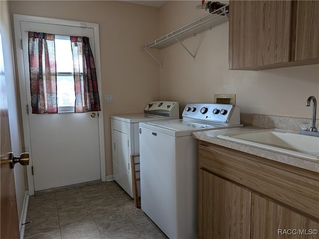 laundry room with cabinets, washing machine and dryer, and sink